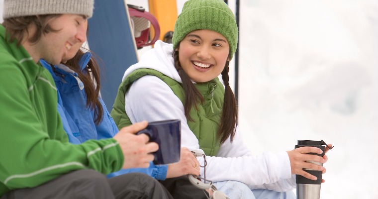 Two people at a ski resort having a warm drink