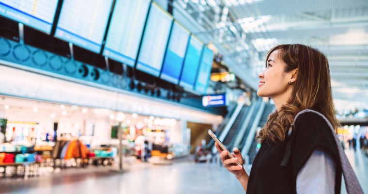 A woman looking at the departures board at the airport