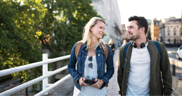 A couple walking in the street with backpacks on