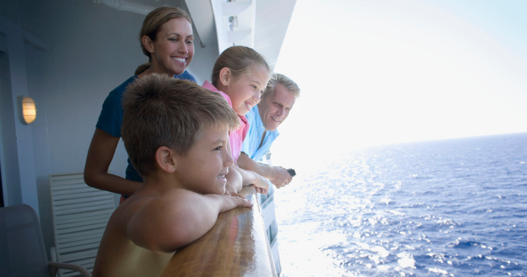 A family looking at the ocean from a cruise ship balcony